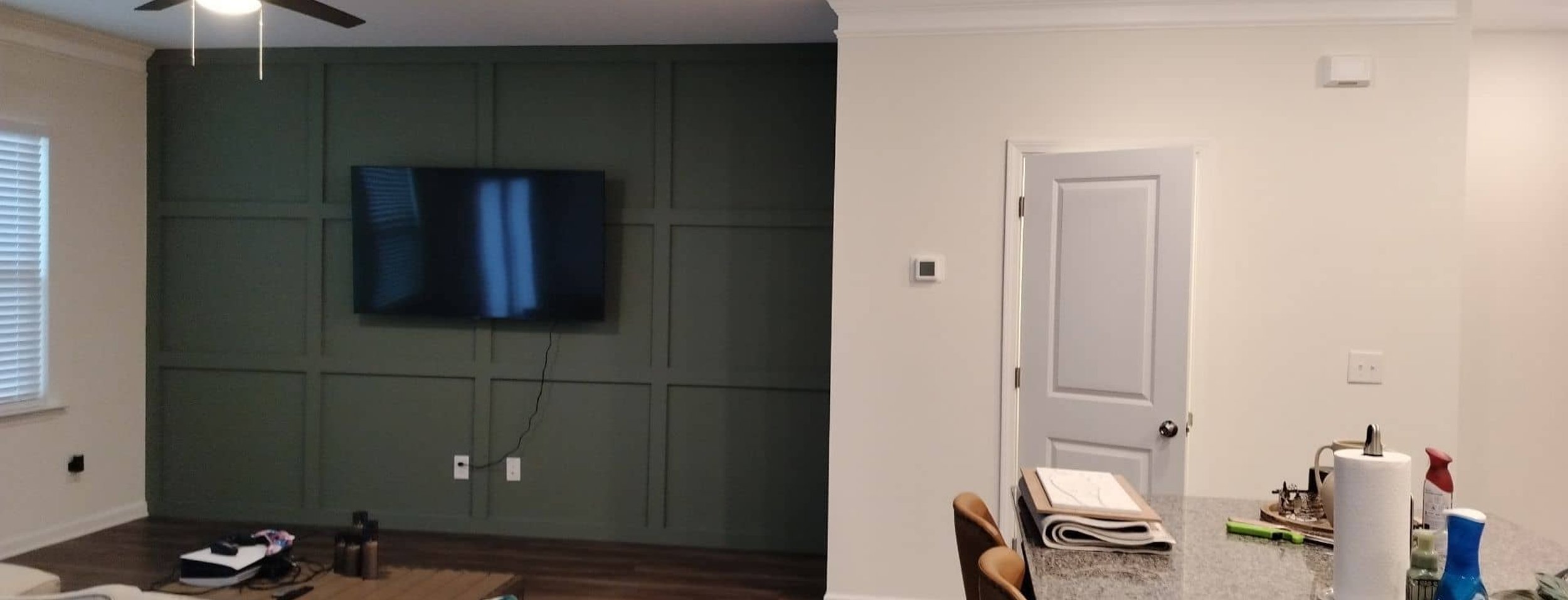 Interior living room with freshly painted dark green board and batten accent wall