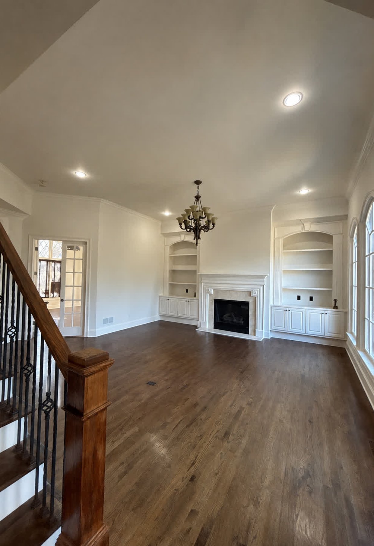 Freshly painted interior room with white built-in shelving and fireplace